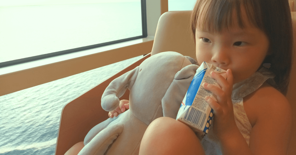 image of a little girl drinking milk packet